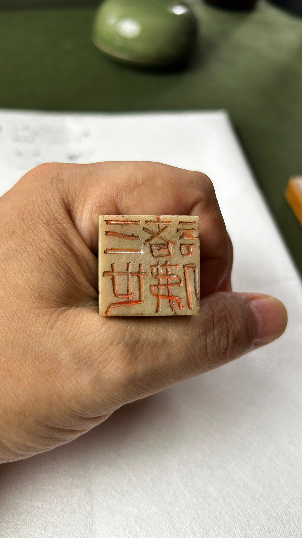 Hand‑held Qingtian stone seal, close‑up view of carved seal face