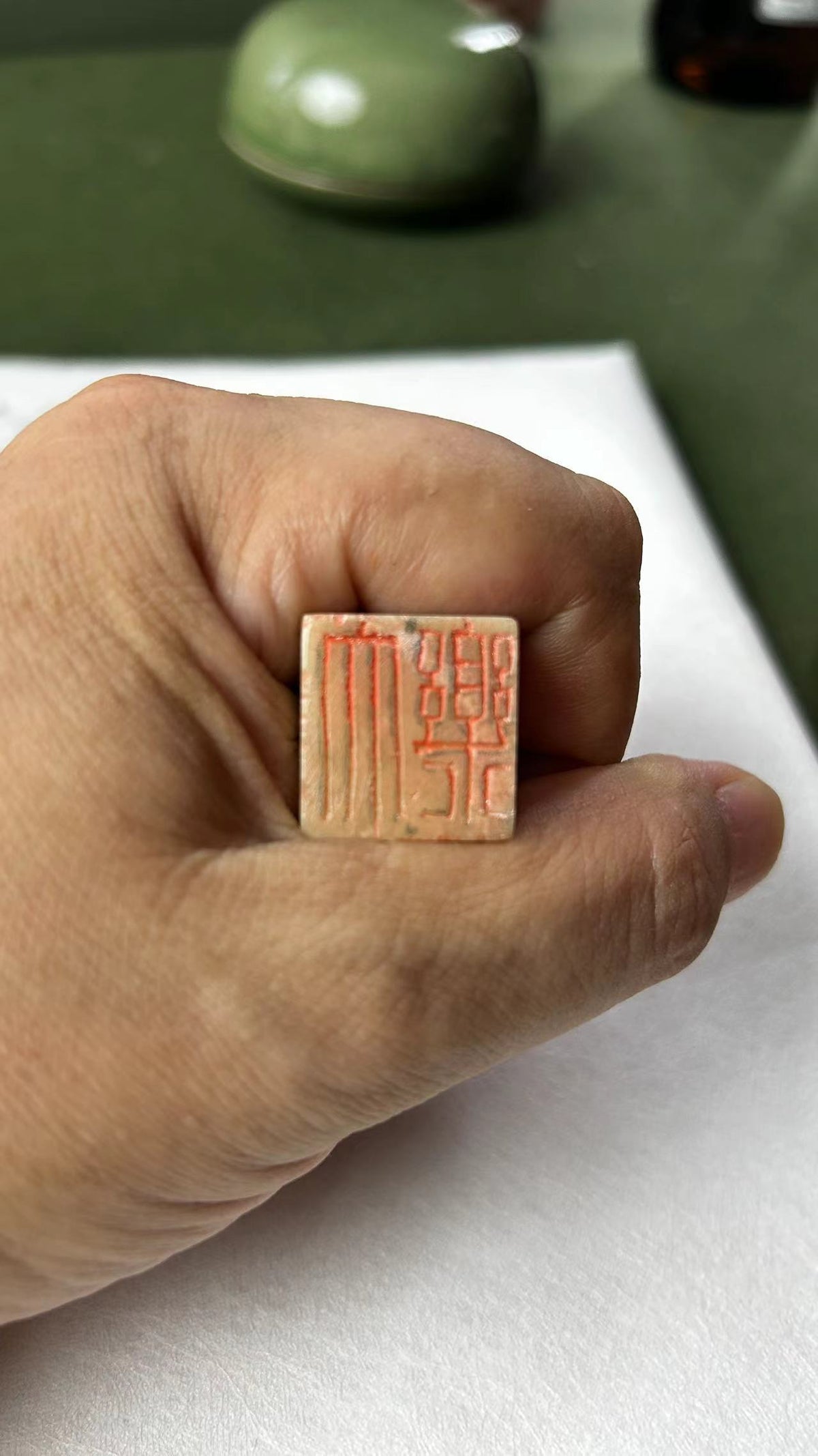 Hand‑held Qingtian stone seal, close‑up of carved stamp surface