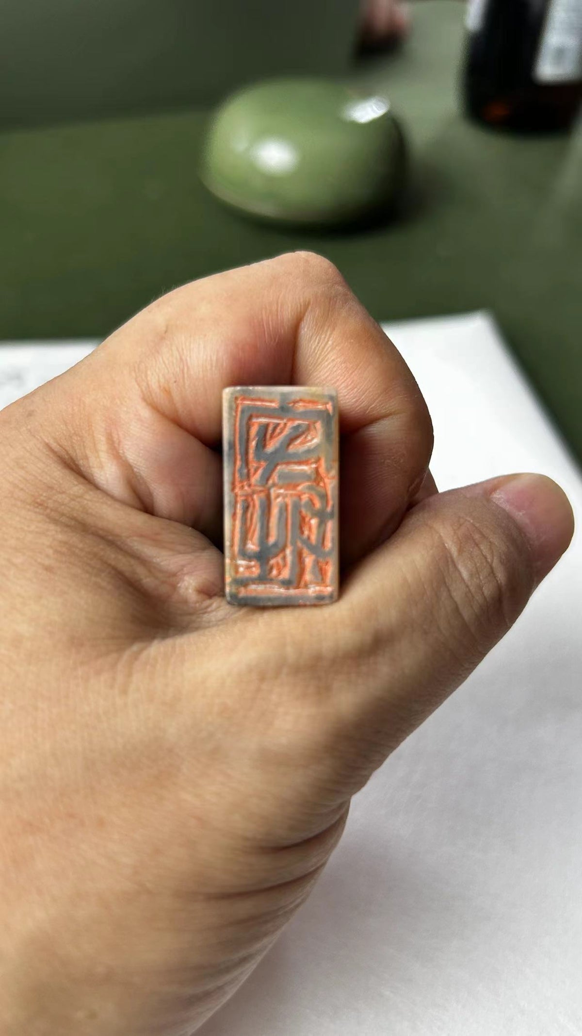 Hand‑held Qingtian stone seal, close‑up of carved stamp face