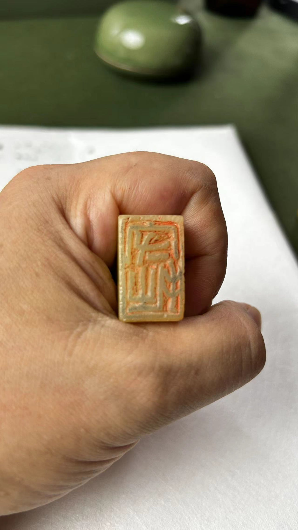Hand‑held cauliflower‑yellow Qingtian stone seal, close‑up of carved stamp surface