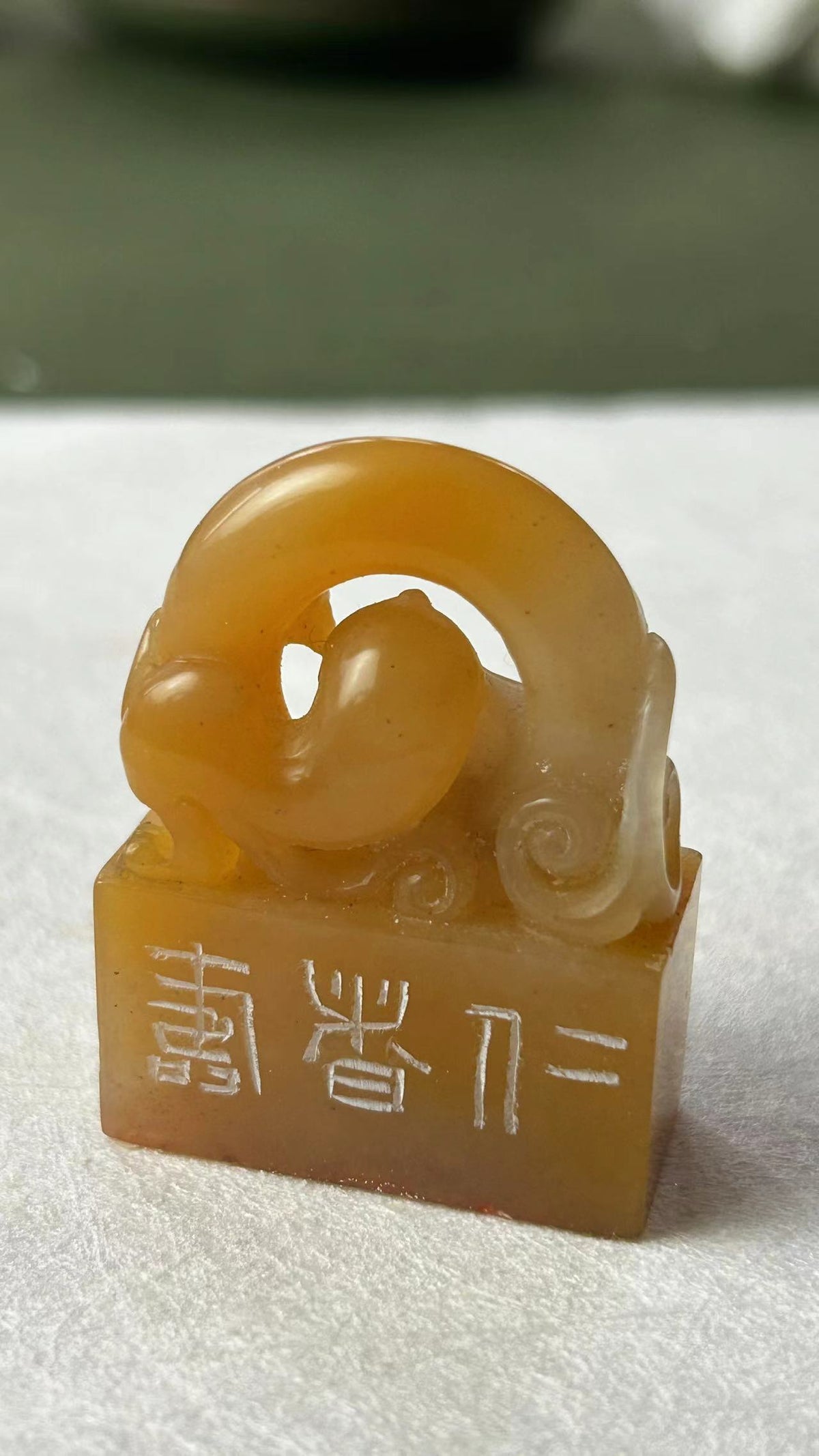 Full view of seal with intricately carved hollow mythical beast knob and side characters