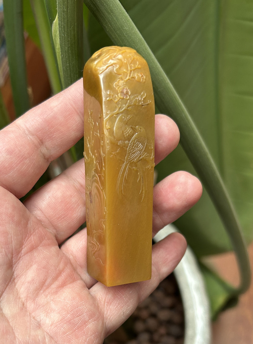 Lao Bei Bu Tian Huang Shi tall rectangle seal blank 2x2x8.5cm hand engraved floral bird relief studio shot held in hand