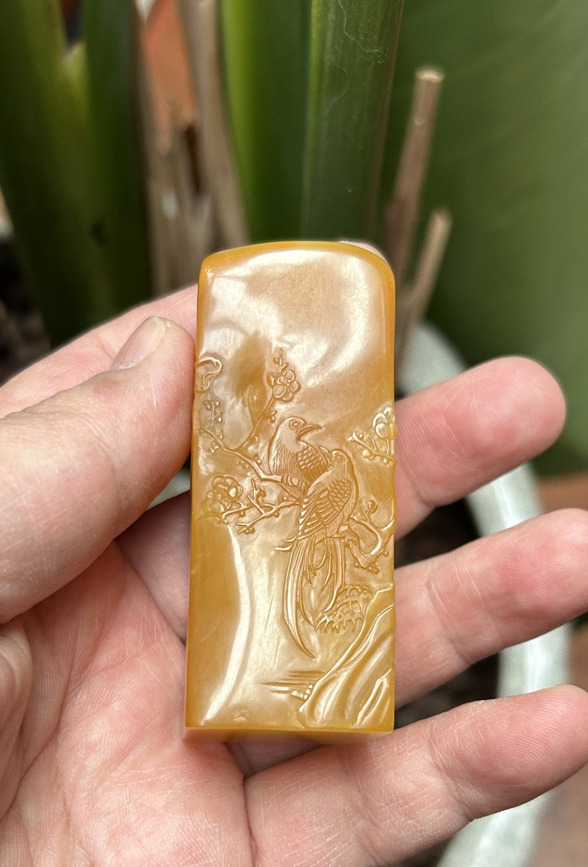 Laos Northern Tian Huang Stone square seal blank 2.7x2.7x7cm hand carved bird flower relief side view studio shot held in hand