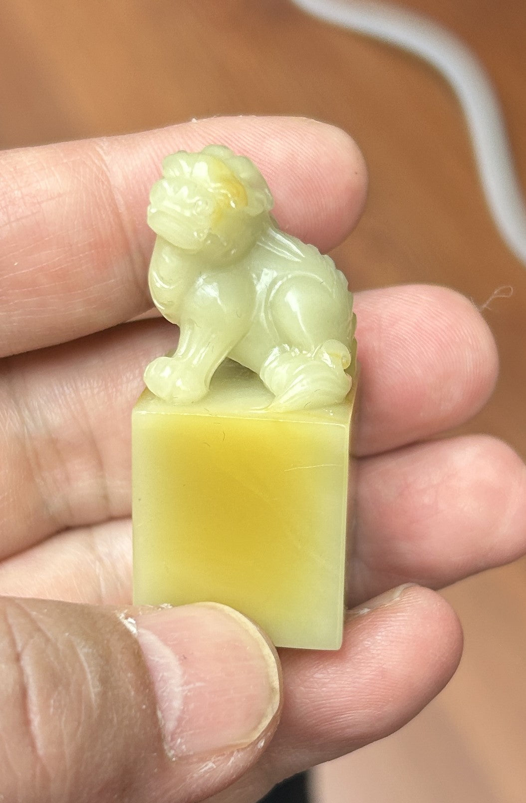 Qingtian Caihua yellow stone seal set 5 pieces hand carved beast knobs various sizes studio shot held in hand with wooden display stand