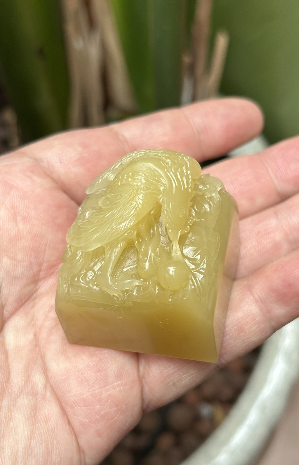 Diagonal close-up of phoenix holding pearl sculpture on natural Laos stone seal blank