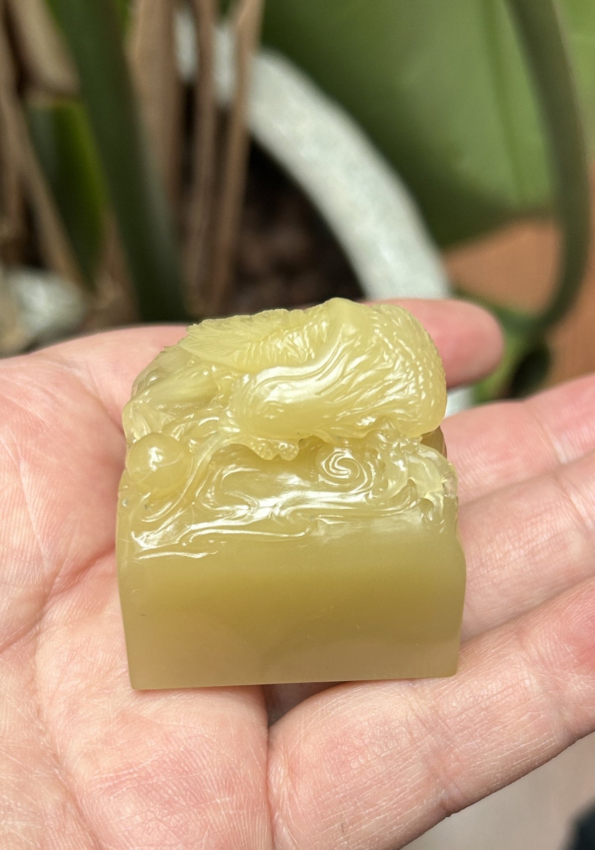 Top-down view of hand carved phoenix and pearl relief on Laos stone square seal