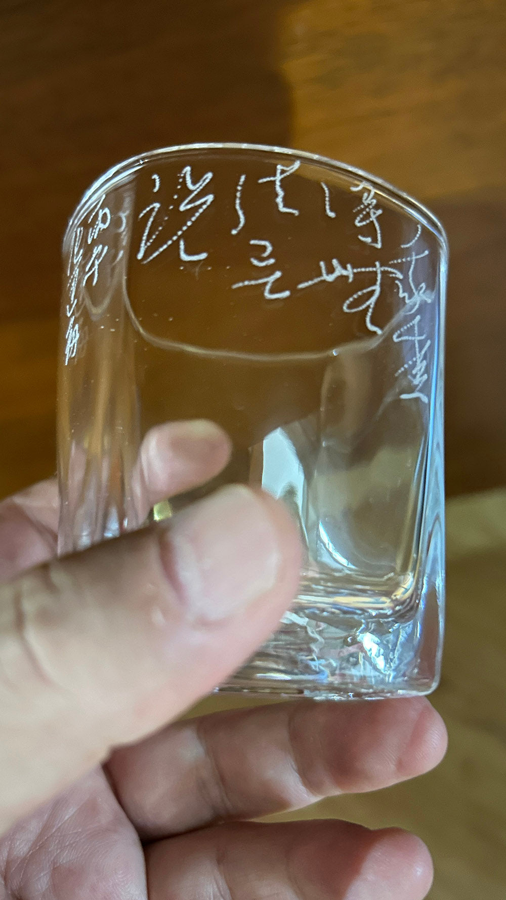 Close‑up handheld view, showcasing hand‑frosted cursive engraving details on clear tumbler
